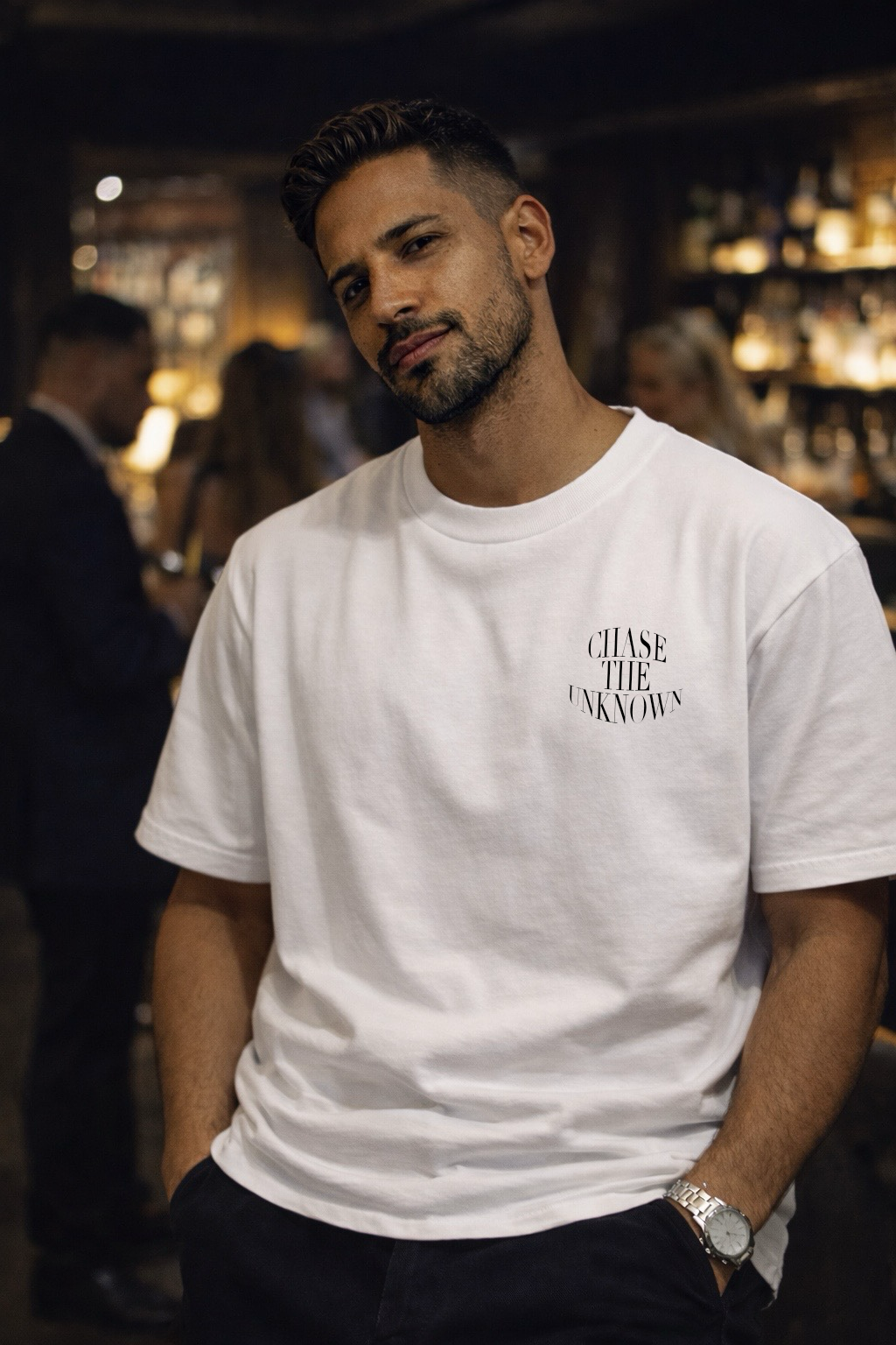 Man wearing a white t-shirt with text in a bar setting