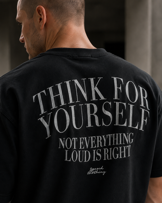 A man viewed from behind wearing a black graphic t-shirt with the text 'THINK FOR YOURSELF NOT EVERYTHING LOUD IS RIGHT' printed in white on the back.