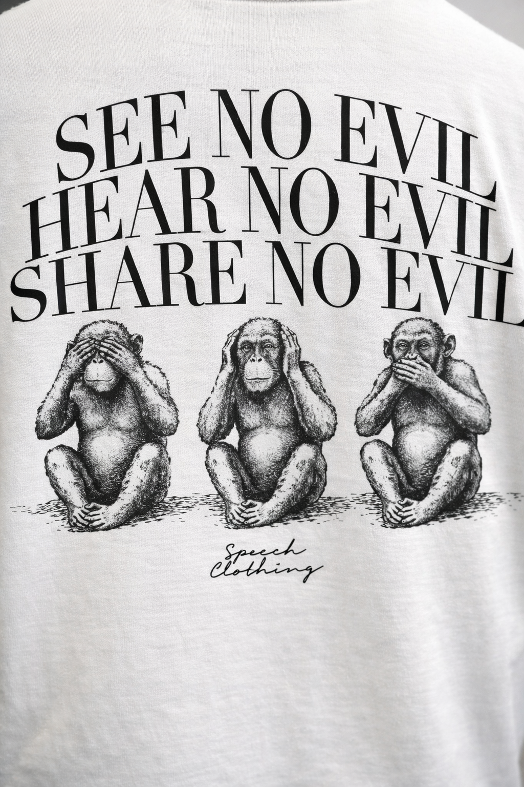 White t-shirt with black text and monkey illustrations on a white background