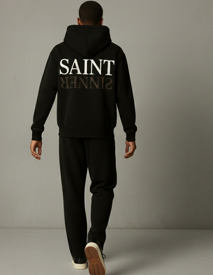 Person wearing a black hoodie with 'SAINT SINNER' text on the back against a gray background