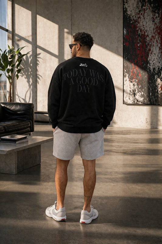 Person wearing a black sweatshirt with text in a modern indoor setting