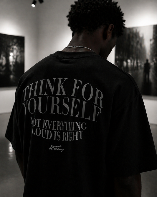 Person wearing a black t-shirt with text on the back in an indoor setting.