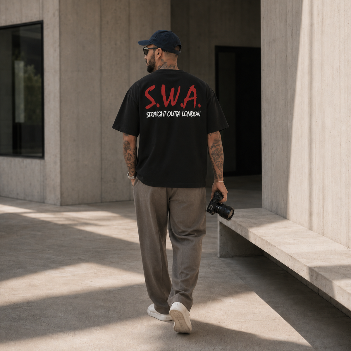 A man wearing a black t-shirt with red and white 'S.W.