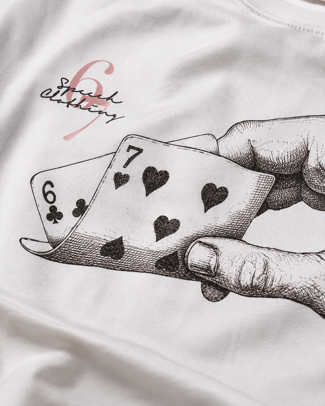 White t-shirt featuring a black ink sketch of a hand holding playing cards (6 of clubs and 7 of hearts) with a pink 'Squad Editing' logo printed on the chest.